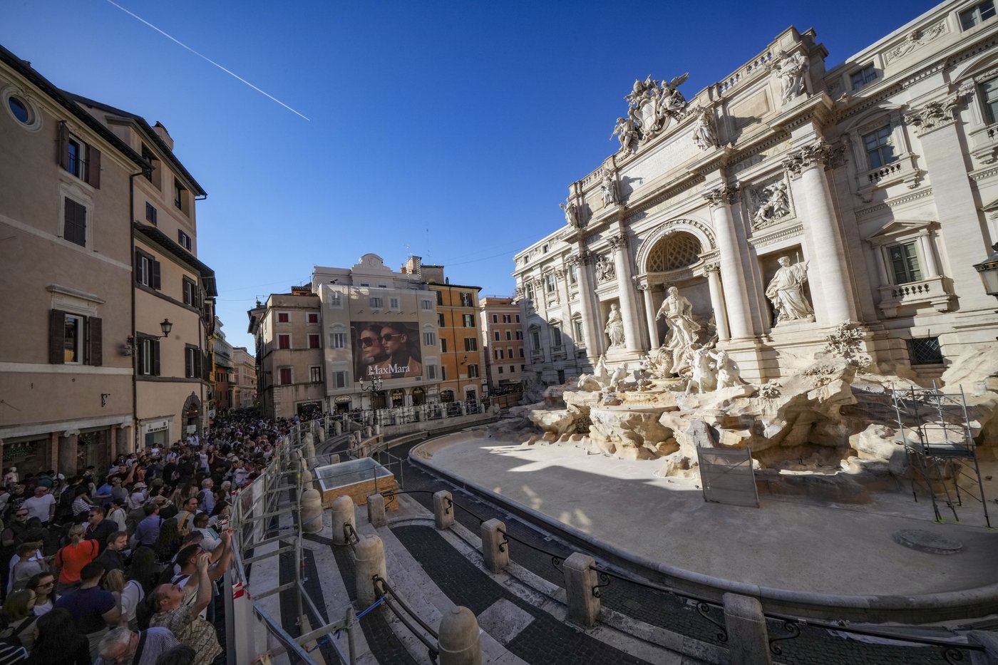 Tourists toss coins over a makeshift pool as Rome’s Trevi Fountain undergoes maintenance | iNFOnews.ca