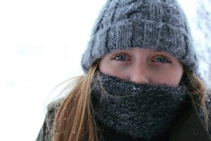 A photo of a woman in a toque and a scarf on a winter day.