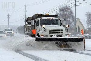 A snow plow on a city road.