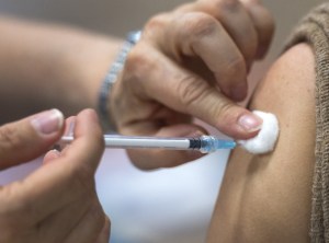 A person receives an injection in their arm.