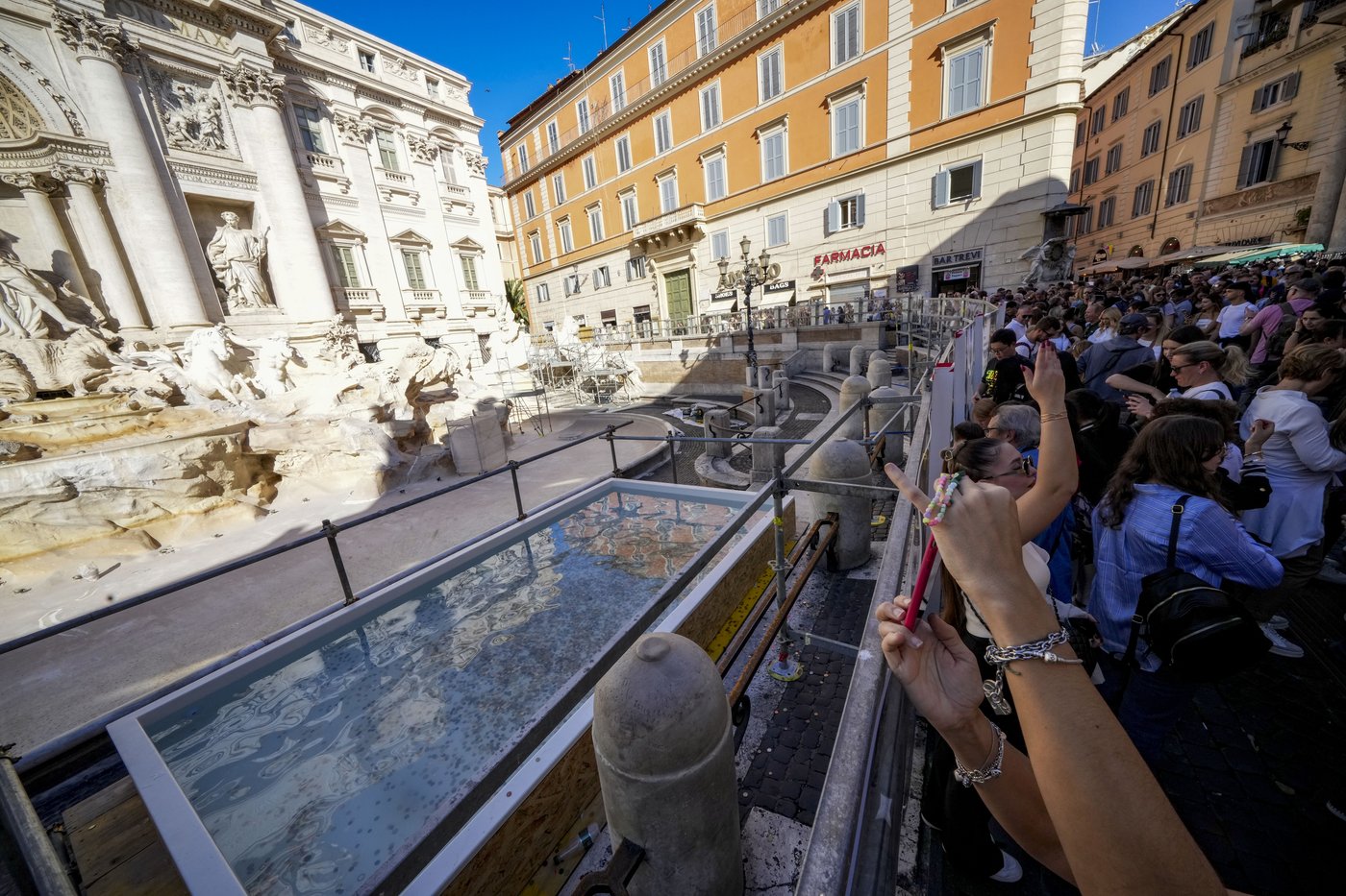 Tourists toss coins over a makeshift pool as Rome’s Trevi Fountain undergoes maintenance | iNFOnews.ca