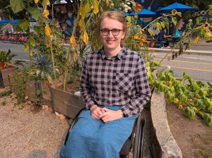 A smiling woman sitting in a wheelchair.