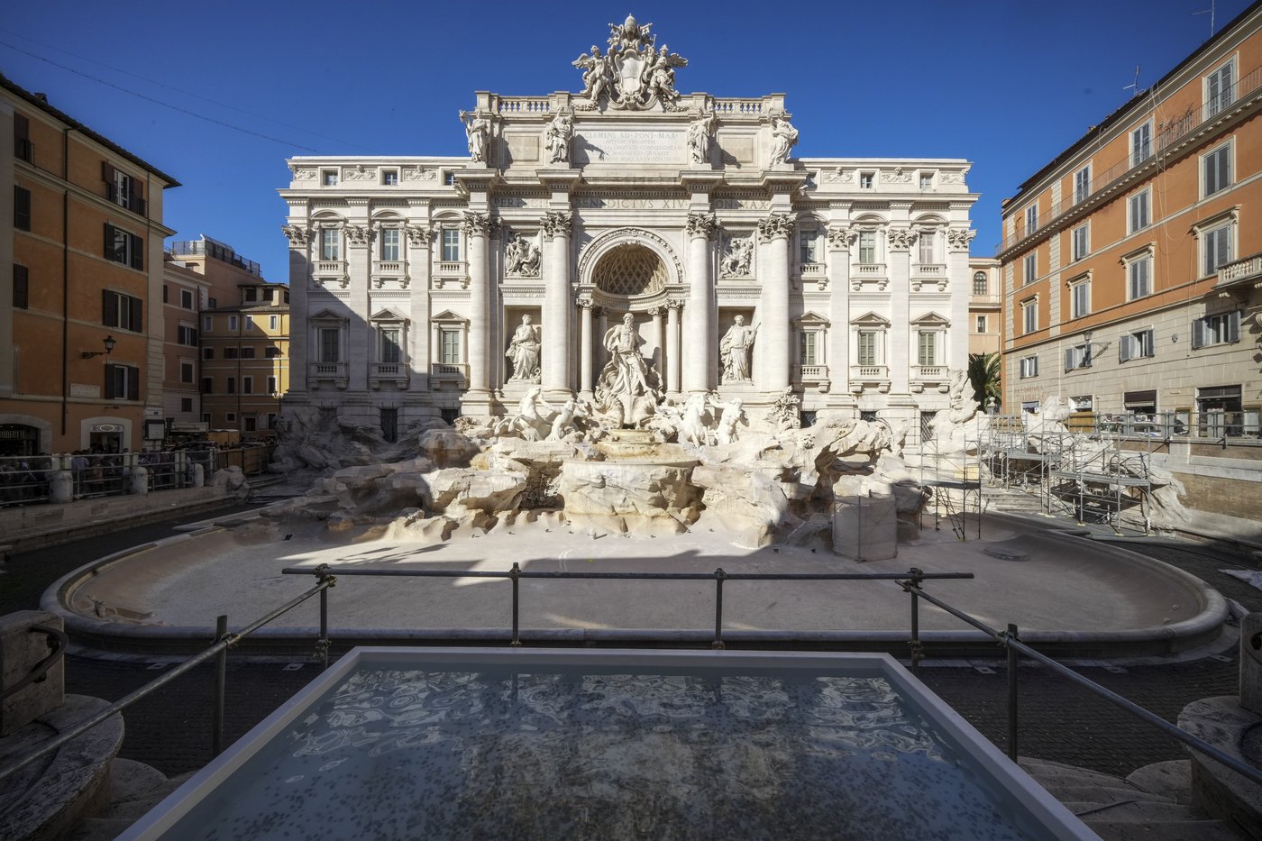 Tourists toss coins over a makeshift pool as Rome’s Trevi Fountain undergoes maintenance | iNFOnews.ca