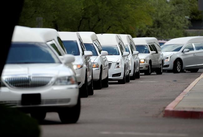 10 white caskets and memories: Funeral honours flood victims | iNFOnews.ca CP1960500684