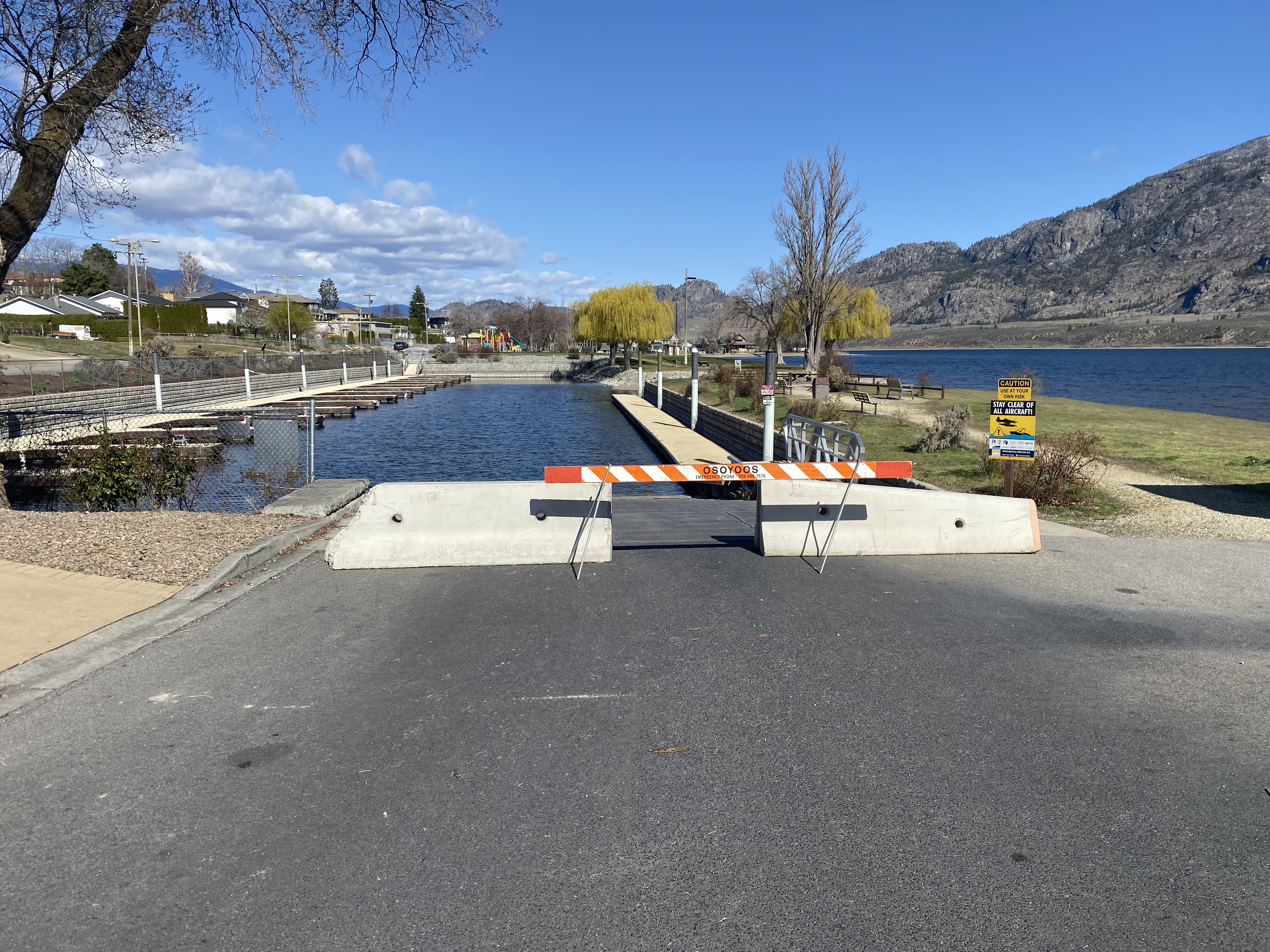 Drought declaration means low water level for Okanagan Lake basin | iNFOnews.ca A road barrier blocking access to a boat launch on a sunny day.