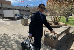 Man in a suit leaves a courthouse.