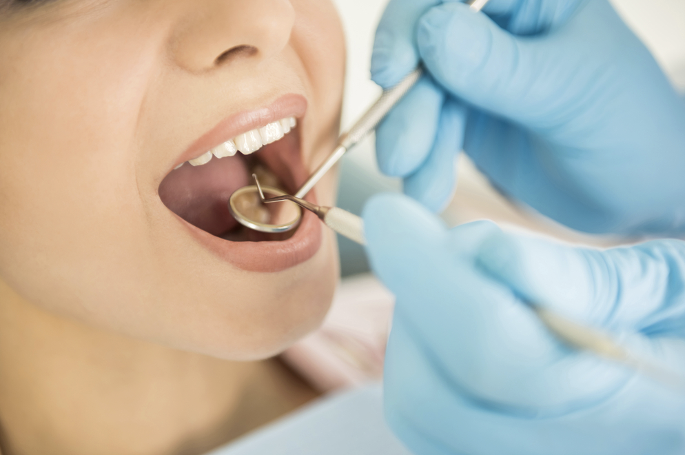 Salmon Arm denturist reprimanded for working without registration | iNFOnews.ca A dentist looks into a patients mouth with a mirror.