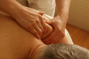 A massage therapist massages a client's back.