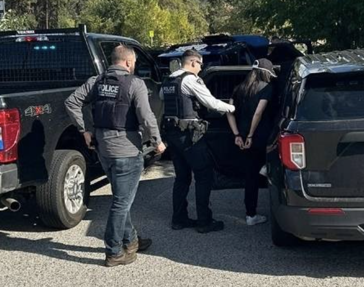 West Kelowna RCMP arrest 50 people in ‘Project Deadbolt’ | iNFOnews.ca Two police officers putting someone in handcuffs into a vehicle.