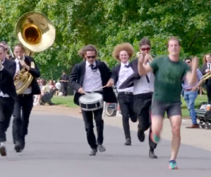 Men playing brass instruments while jogging.