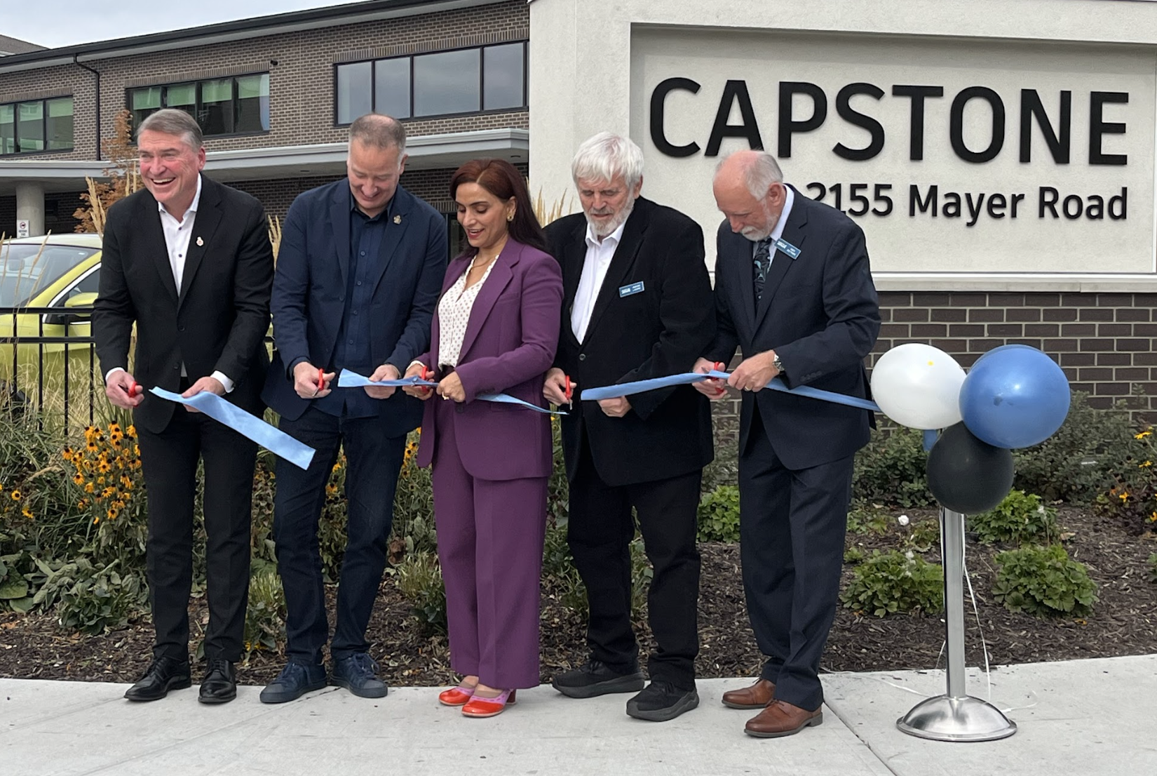 Politicians and board members at a ribbon cutting ceremony.