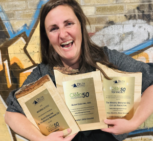 A woman holding several awards.