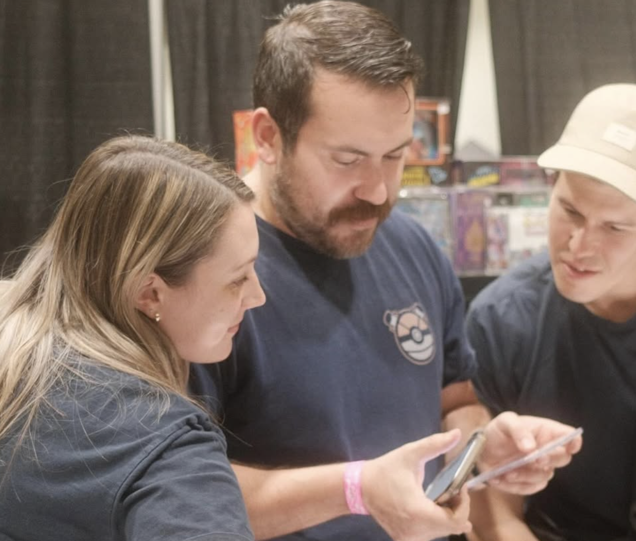 Vernon man turns childhood Pokémon hobby into an award winning business | iNFOnews.ca Two people looking at someone going through Pokèmon cards.