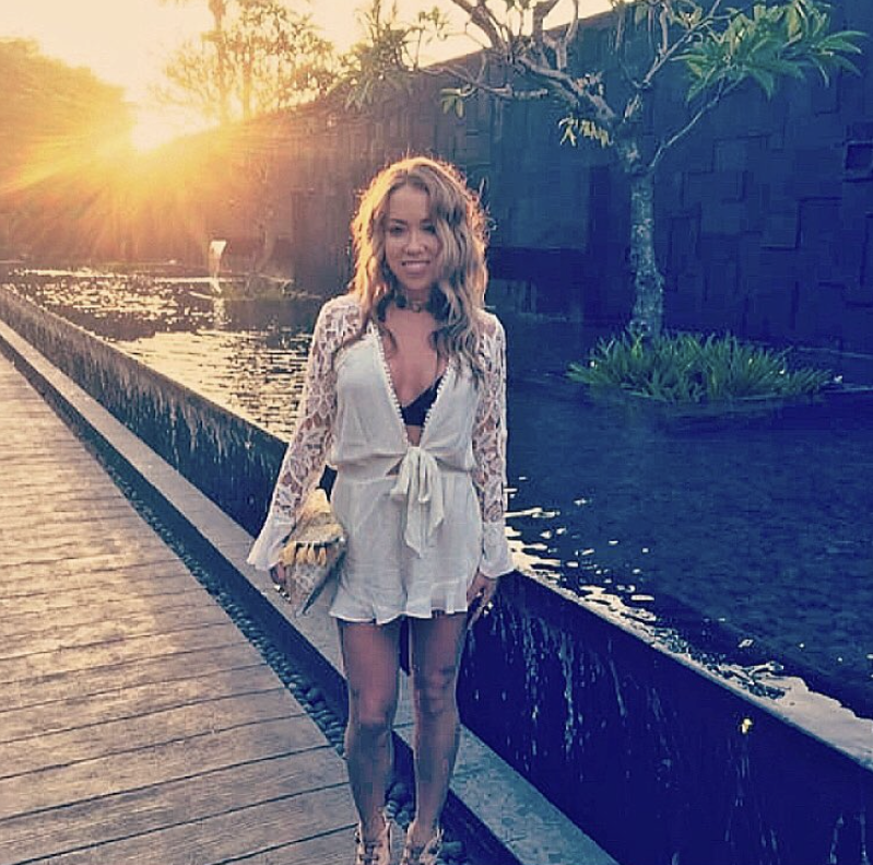 Kaitlynn Fleury wears a white dress standing next to a pond.