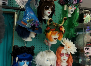 Wigs and hats and glasses on manakin heads.