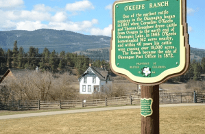A sign with an old church in the background.