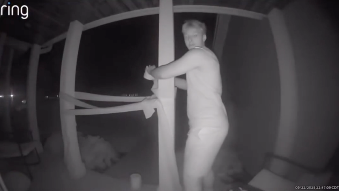 A boy with a roll of toilet paper is seen on a front porch.