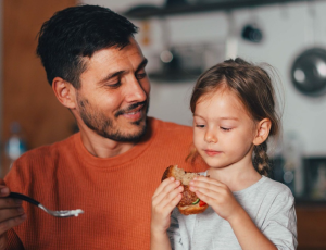 A man and a young girl sharing a meal.