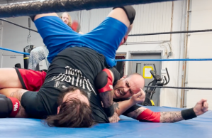 Two pro wresters rolling around in the ring.
