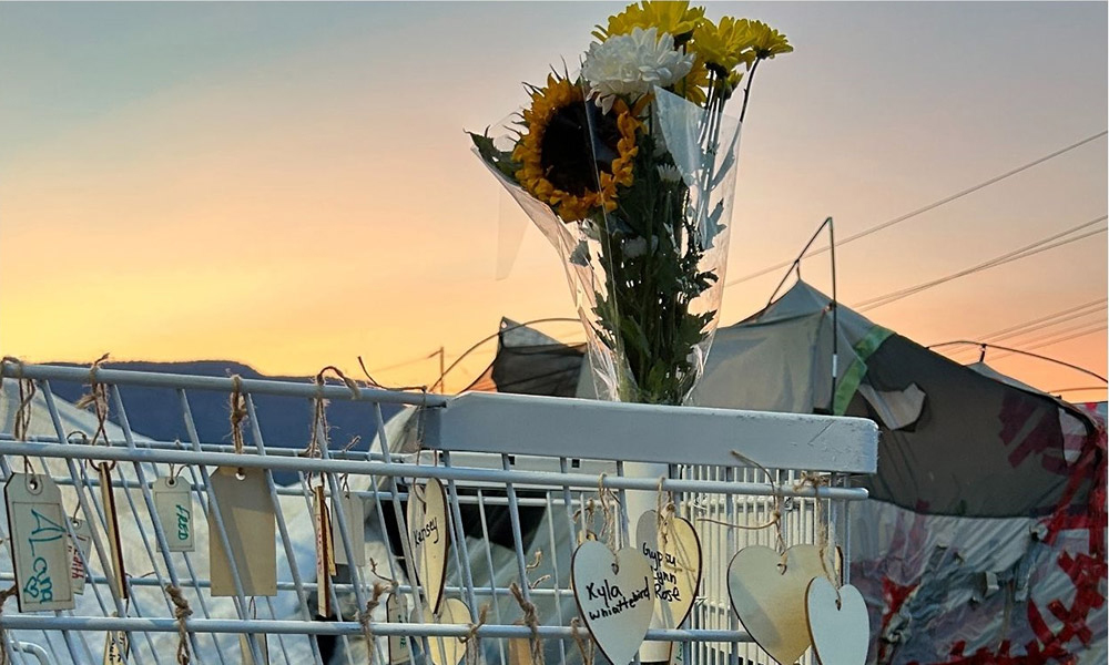 A bouquet of flowers atop a white painted shopping cart.