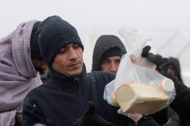 Migrants in burnt Bosnia camp wait for new tents in blizzard | iNFOnews.ca