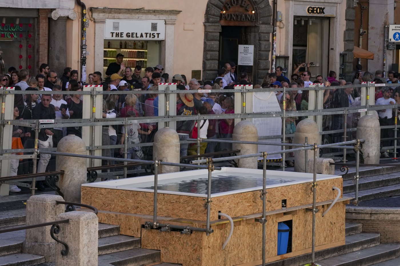Tourists toss coins over a makeshift pool as Rome’s Trevi Fountain undergoes maintenance | iNFOnews.ca