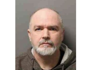 A mugshot of an old white guy with a grey goatee.