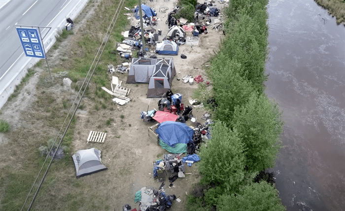 Housing ministry looks elsewhere as Penticton denies tiny homes for homeless | iNhome An aerial view of a homeless encampment with tents and debris.