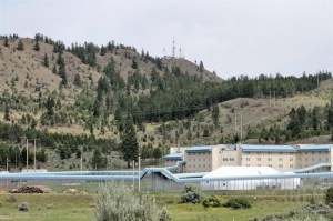 A jail is backed by towering grassy hills.