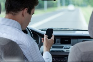 Man texting while driving a car