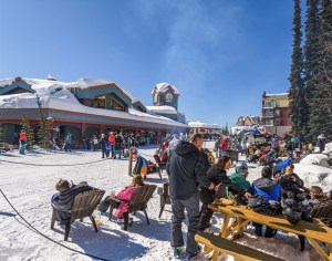 The Big White Ski Resort village packed with people on a bright winter day.