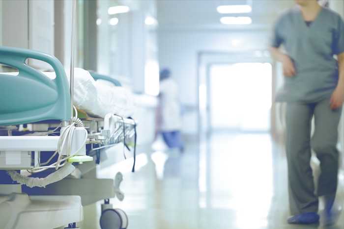 A doctor walks through a hospital corridor.