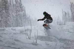 Teenager snowboarding in heavy snow.