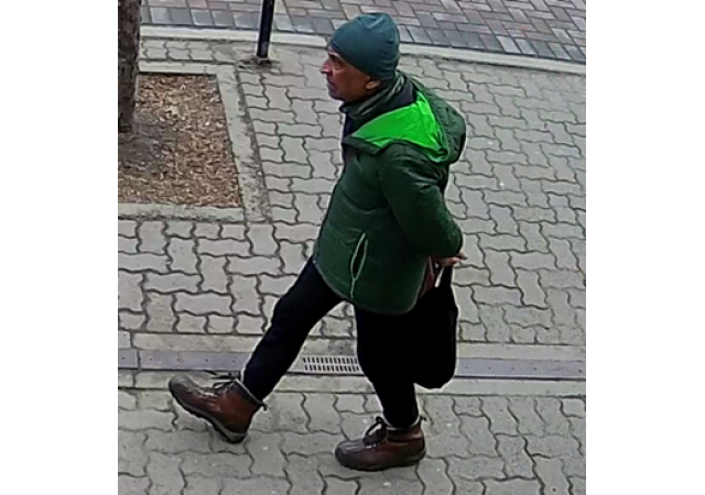 A surveillance photo of Mohd Abdullah walking on a sidewalk.