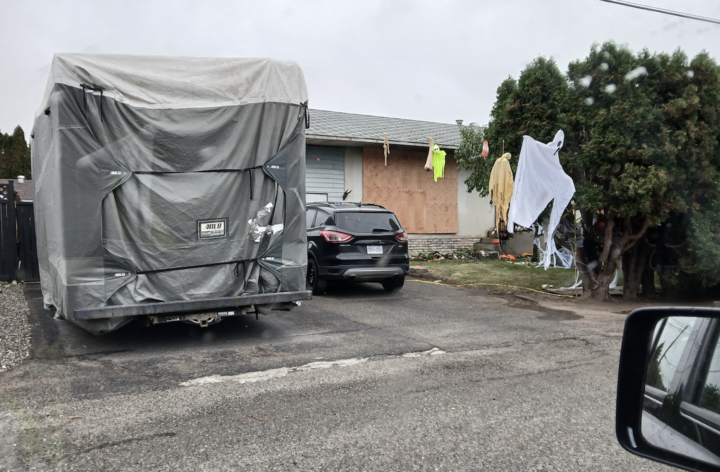 Kamloops family seriously injured in house fire | iNFOnews.ca A boarded up house with Halloween decorations in the front yard.