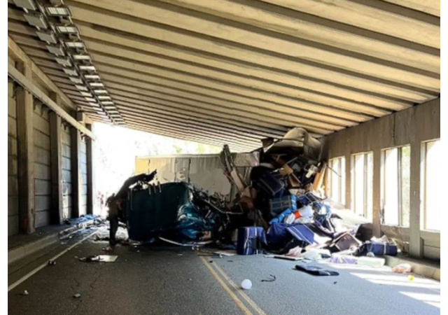 Debris in highway tunnel after semi-truck crash.
